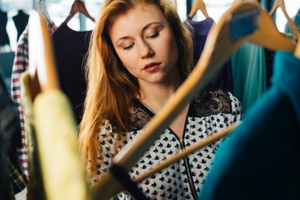 woman choosing clothes from closet